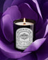 Pyneyard Rose Scented Candle with a label in front of a purple flower