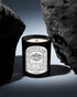 Pyneyard Ylang Ylang Scented Candle with a label in a dark setting known as god complex