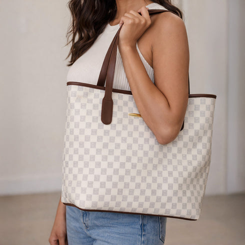 Person holding a Kleio White checkered tote bag with brown accents from Pyneyard